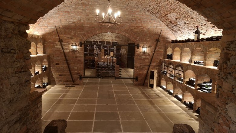 Wine cellar in Dürnstein Castle, © Johannes Christian Thiery Historic wine cellar with brick walls and wine racks.
