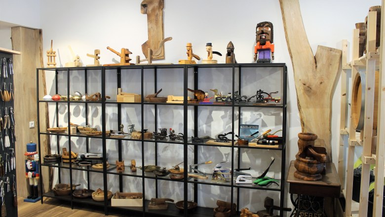 tour-1, © Johann Peham Shelf with wooden objects and tools in a showroom.