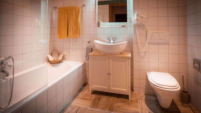 Bathroom - Deluxe double room with garden view, © Schlossschenke Modern bathroom with bathtub, washbasin and toilet.