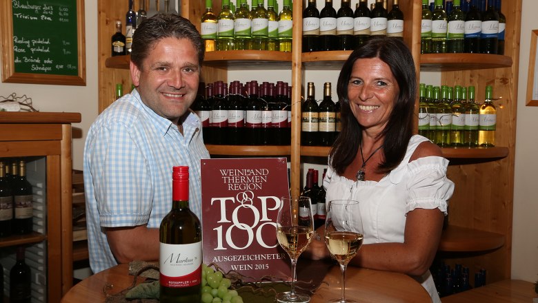 Gausterer, © Gausterer Markus Two people in a wine store with bottles of wine in the background.
