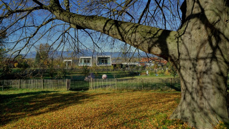 Garden lofts in the fall, © Gut Guntrams Autumn landscape with trees, foliage and modern buildings in the background.