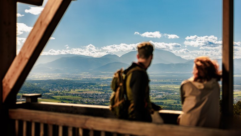 View of the Alps with Schneeberg from the observation tower, © Wiener Alpen, Fülöp, Kremsl Two people enjoy the view from a vantage point over a vast landscape with mountains in the background.