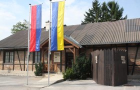 Museum of local history, © Gemeinde Strasshof Entrance to the Strasshof museum of local history with two flagpoles and a wooden fence.