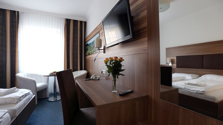 Country inn Moshammer, © Weinfranz Modern furnished hotel room with double bed, desk, flat screen TV and bouquet of flowers.
