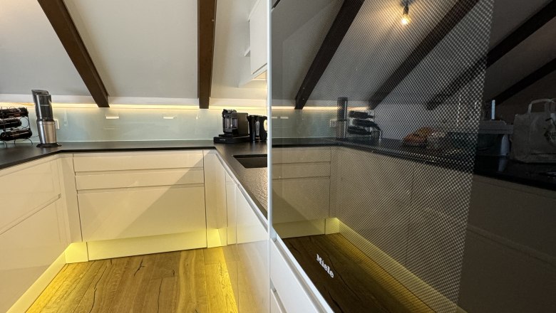 Kitchen, © Juwel am Stadtrand Modern kitchen with wooden floor, white cupboards and built-in oven.