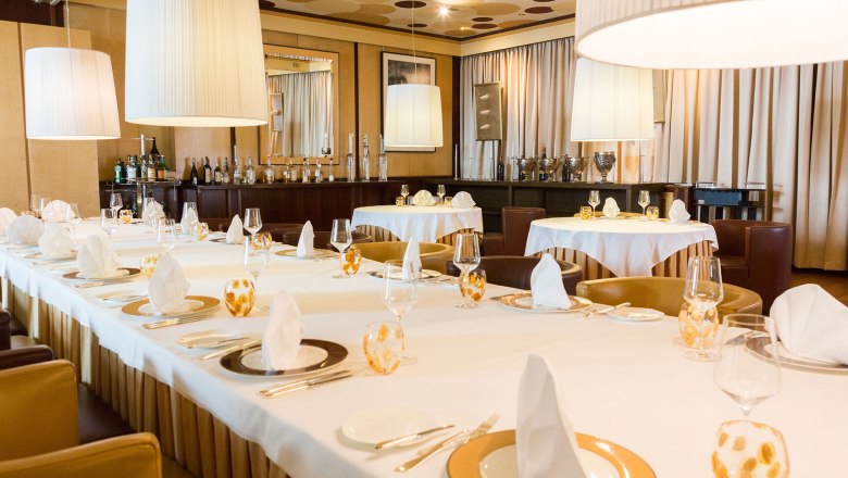 Dining room, © Mörwald Elegant dining room with laid tables, white tablecloths and large hanging lamps.