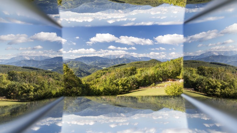 Viewpoint Waxeneckhaus, © Wiener Alpen, Foto: Franz Zwickl Reflection of a mountain landscape with blue sky and clouds.