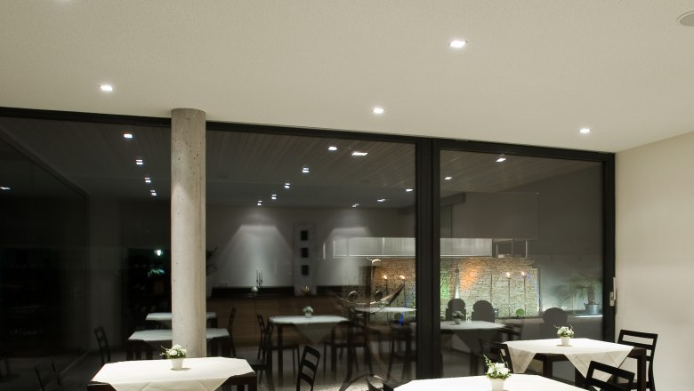 Breakfast room, © Rosenberger Modern breakfast room with tables and chairs, decorated with white tablecloths and flowers.