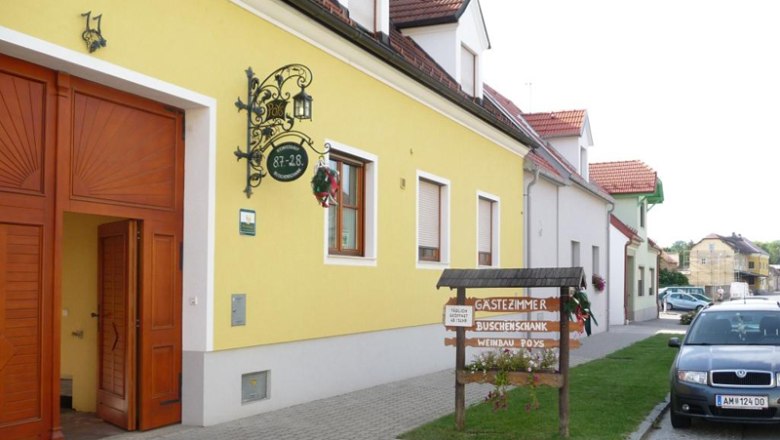 Winegrowing Buschenschank (typical tavern) guest room Susanna Poys, © Familie Poys Yellow building with sign 'Gästezimmer Buschenschank Weinbau Poys' and parked car in front of it.