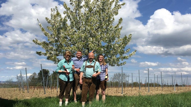 Scharnagl family, © Fam. Scharnagl Four people are standing in front of a blossoming tree in a field.