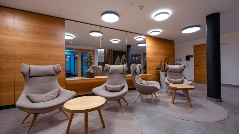 Hotel Schwarz Alm Zwettl, © Niederösterreich Werbung / Maximilian Pawlikowsky Modern hotel lobby with comfortable armchairs and wooden tables.
