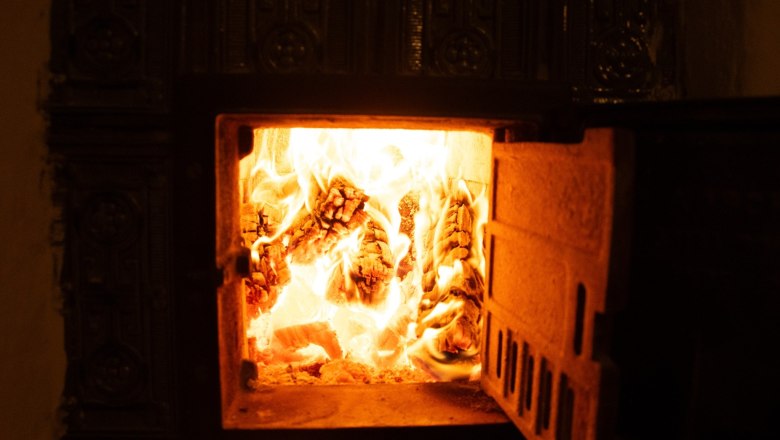 Orlet on the Rax, © Sofia Orlet A burning fireplace with visible flames and logs.