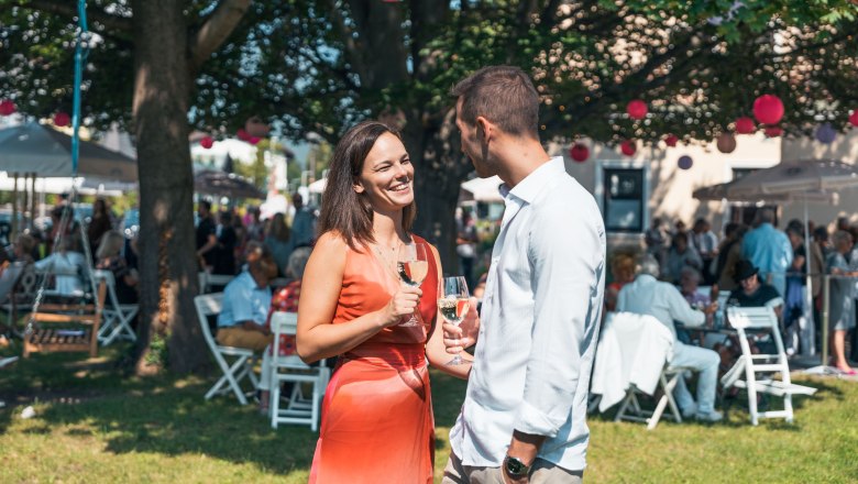 Reichenau Festival, © Österreich Werbung/Stefan Strasser Two people outdoors with wine glasses in their hands.