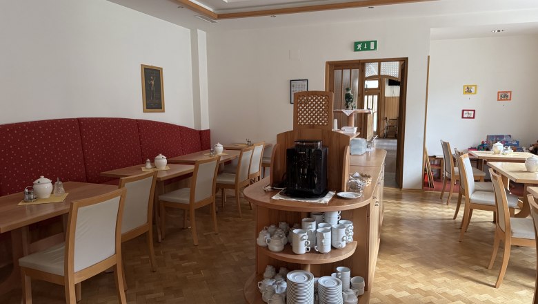 Hotel Zur Alten Schule, © Viregro Capital Gmbh Interior view of a breakfast room with wooden furniture and crockery.