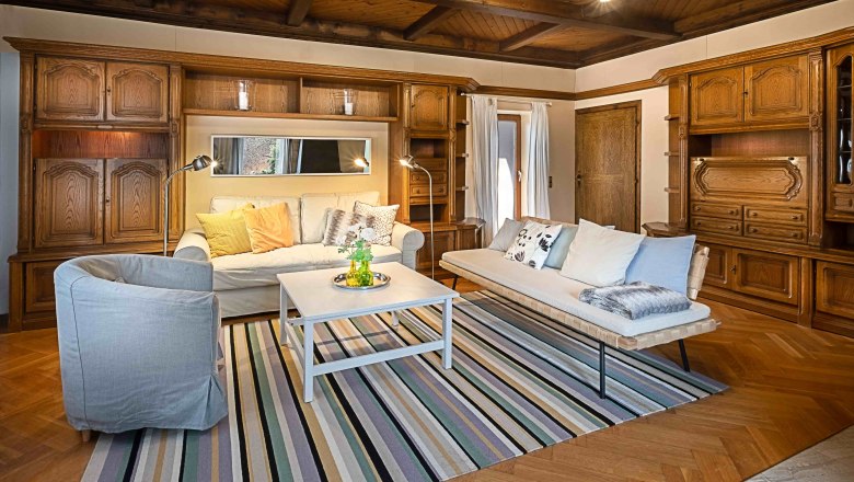 Top 1 - Living room, © VP FeWo OG Cozy living room with wooden furniture, sofas, carpet and coffee table.