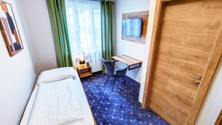 TDR-Smarthotel-EZ, © Schmid 1954 GmbH Single room with desk and window, blue carpet