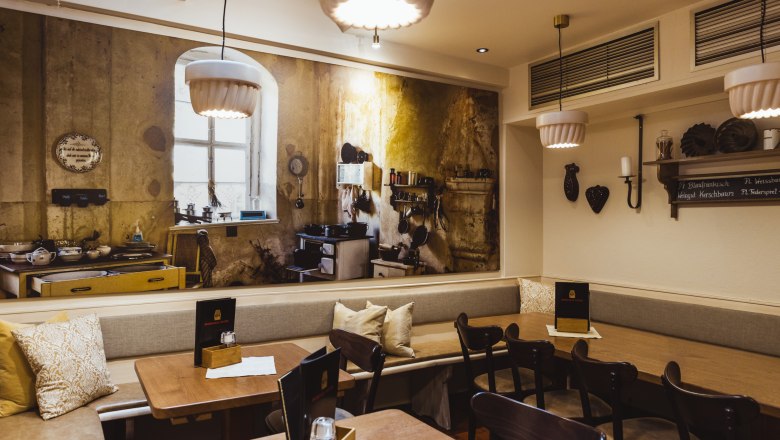 A pub steeped in history, © Niederösterreich Werbung/David Schreiber Cozy restaurant with a rustic mural of an old kitchen.
