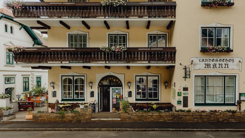 Inn at the foot of the Rosenburg, © Niederösterreich Werbung/Sophie Menegaldo Facade of a traditional inn with balconies and flower boxes.