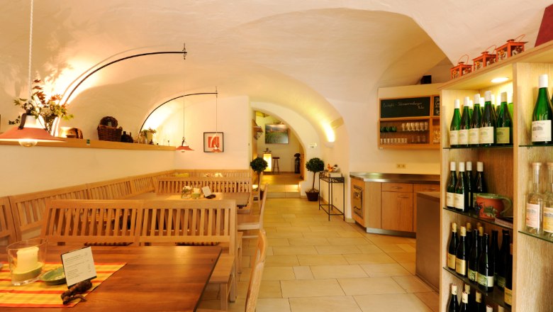 Wine tavern, © Steve Haider Interior view of a cozy wine tavern with wooden tables and wine racks.