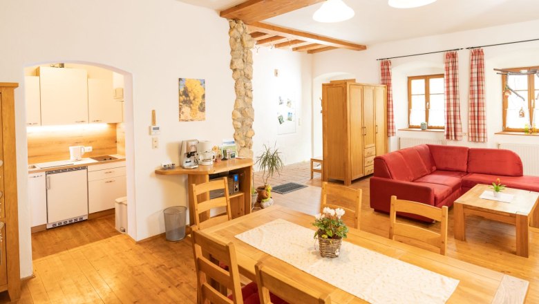 Living space, © Fam. Zangl Cozy living room with wooden furniture, red sofa and open kitchen.