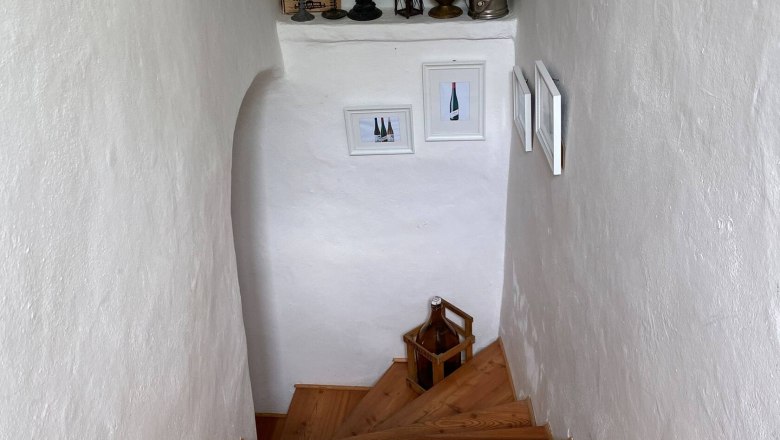 Staircase, © Familie Stagard Wooden staircase in a white stairwell with decorations and pictures on the walls.