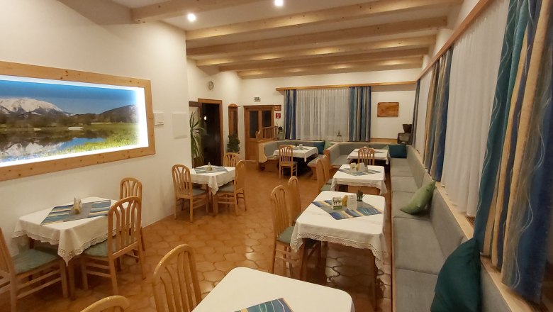 Parlor, © Martin Zwinz Cozy restaurant with wooden furniture and a mountain picture on the wall.