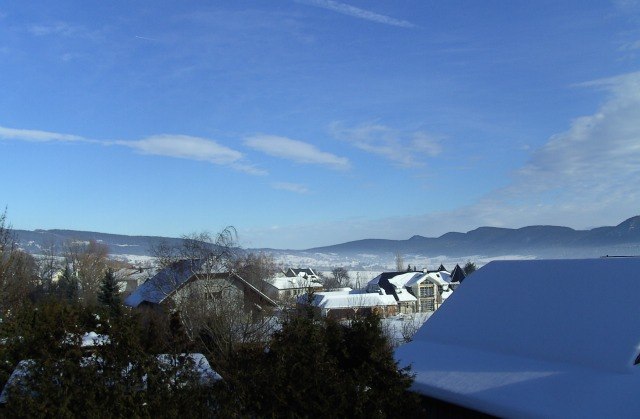 View of the valley from the maple room, © Reep Winter landscape with snow-covered roofs and mountains in the background.