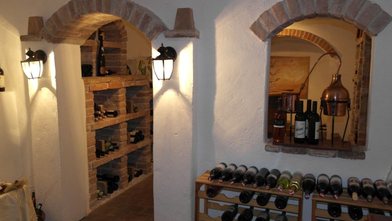 Wine cellar, © Besta Betriebs GmbH A wine cellar with bottle racks and brick arches.