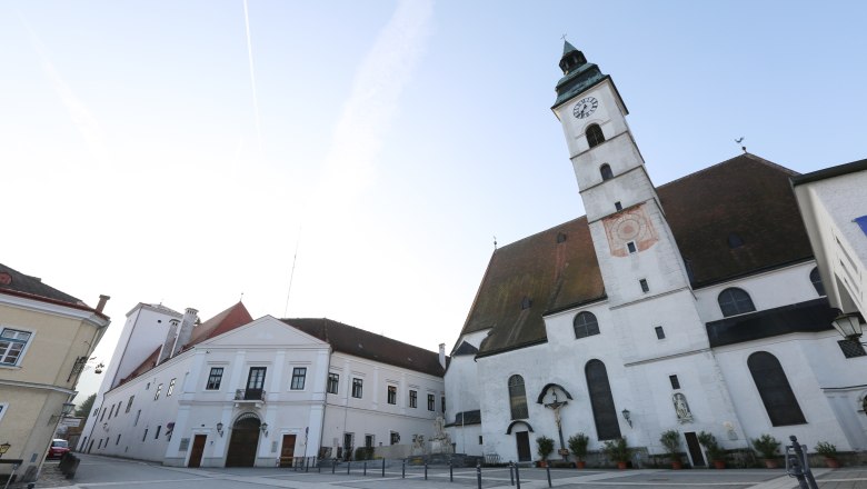 Parish church, © schwarz-koenig.at Parish church with clock tower and adjoining buildings on an empty square.