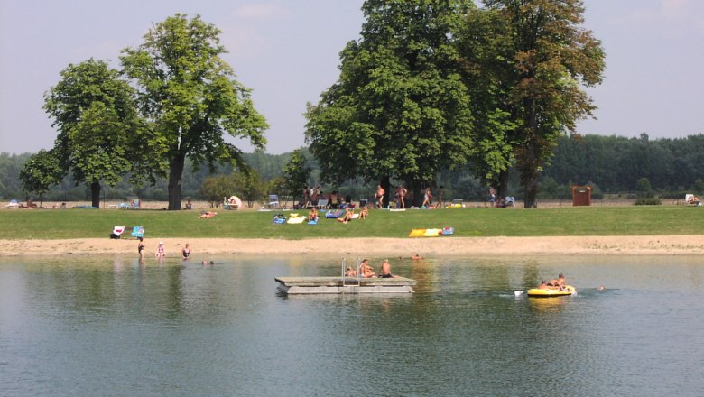 Hohenau, © Gemeinde Hohenau/ March People relaxing by a lake with trees in the background.