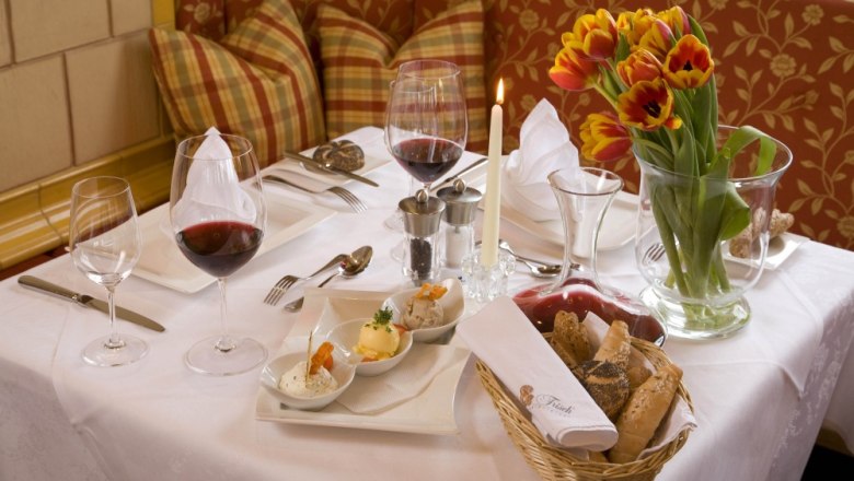 Set table, © Hotel "Wachau" An elegantly laid table with wine glasses, candles, tulips and bread.