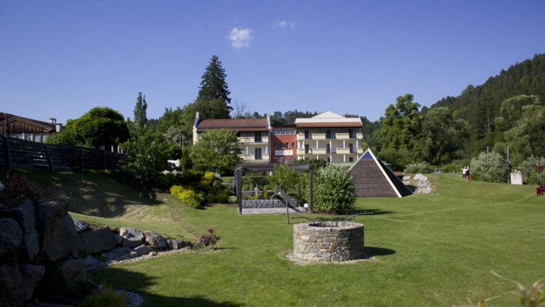 Energy well, © Hotel-Restaurant Liebnitzmuehle GmbH & Co KG A well-tended garden with a fountain in the foreground and a hotel in the background.
