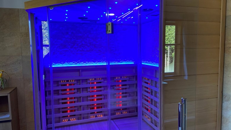 Infrared cabin integrated in the bathroom, © Wiener Alpen Infrared cabin with blue lighting in a bathroom.