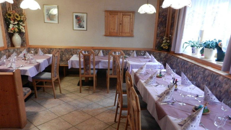 gh_adam_01, © Kirchenwirt Gasthaus Adam Cozy dining room with covered tables and wooden chairs.