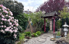 Rainbowsend Family Weber, © "Natur im Garten" A well-tended garden with flowering rhododendrons, a Japanese torii and a stone lantern decor.