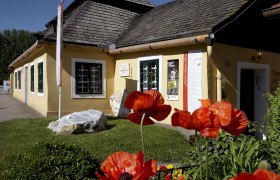Joseph Misson House, © Marktgemeinde Hohenwarth-Mühlbach Yellow house with shingle roof and poppies in the foreground.