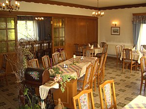 Gasthof Kögl 'Zum Liederfürst', © Gasthof Kögl Interior view of a traditional inn with wooden furniture and decorated tables.