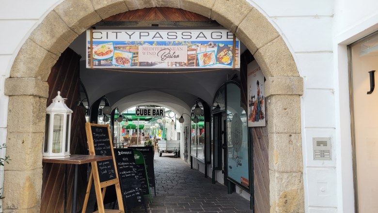 TDR-Mediteranean Wind Bistro, © DNÖ Ketting Entrance to the Citypassage with signs for a bistro and a bar.