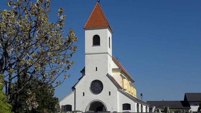 St. Anna Church, Wiesmath, © Haeferl, CC BY-AS 3.0 St. Anna church in Wiesmath with blue sky and blossoming tree in the foreground.