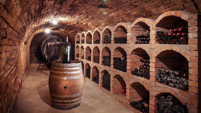 Baier Winery, © Ideenladen Krems Wine cellar with brick vaults, wine racks and a barrel with a large bottle.