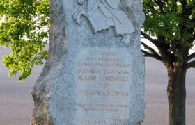 Jedenspeigen memorial stone, © Marktgemeinde Jedenspeigen Memorial stone with knight relief and inscription, surrounded by trees and meadow.