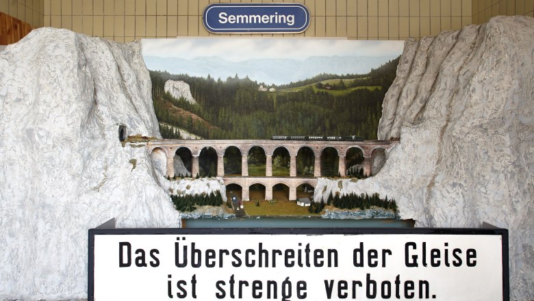 Model of the Kalte Rinne Viaduct, © Wiener Alpen, Foto: Bene Croy Model of the Kalte Rinne viaduct with train and landscape in the background. Sign with inscription: 'Crossing the tracks is strictly forbidden'.
