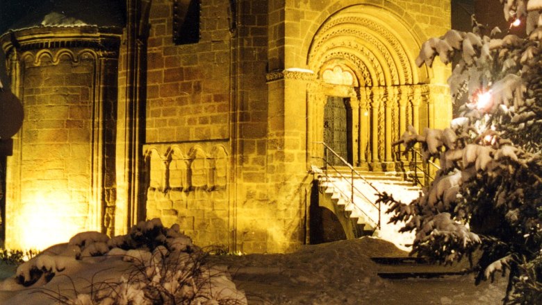 Tullner Karner in the snow, © Stadtgemeinde Tulln The Tulln charnel house at night, surrounded by snow, with illuminated Romanesque architecture.