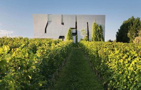 Loisium - World of wine, © LOISIUM/Rainer Mirau Modern architecture behind a green vineyard.