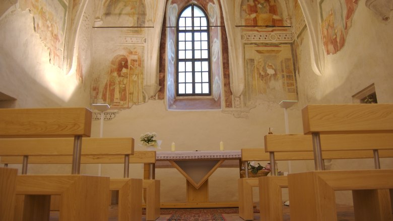 Castle chapel, © Stadtgemeinde Amstetten Interior view of a castle chapel with frescoes and wooden benches.