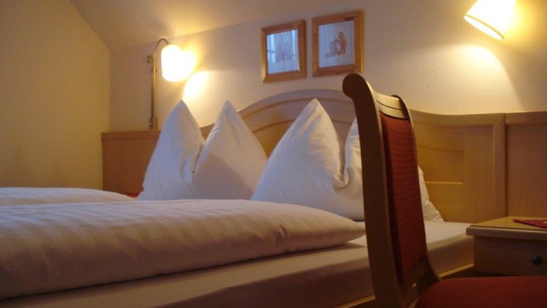 Guest room, © Pension Rudi Cozy guest room with double bed, two bedside lamps and a chair.
