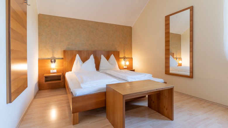 Cozy rooms, © Stefan Jurecek Comfortable bedroom with double bed, wooden furniture and large mirror.