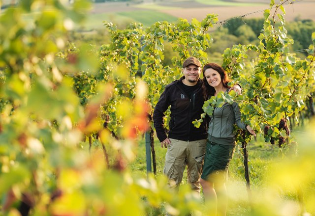 Georg and Helga Toifl, © Michael Reidinger A man and a woman stand smiling in a vineyard.