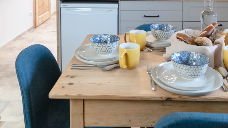 Breakfast detail, © Monika Pölzer Breakfast table in a modern kitchen with blue and white bowls and yellow cups.