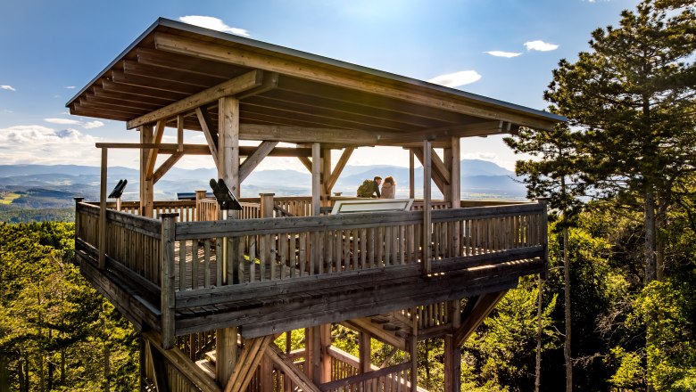 The Lanzenkirchen-Wiesen lookout point, © Wiener Alpen, Fülöp, Kremsl Wooden observation tower in the forest with two people on the platform.